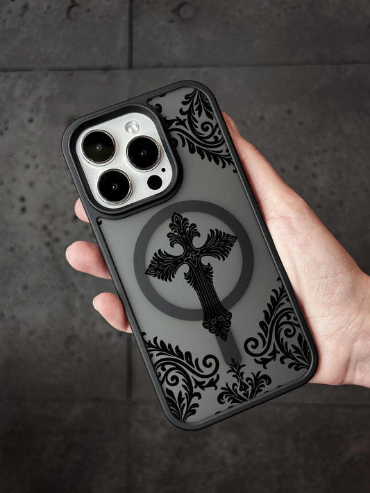 A hand holding a phone case with a black and gray design featuring a cross and floral patterns.