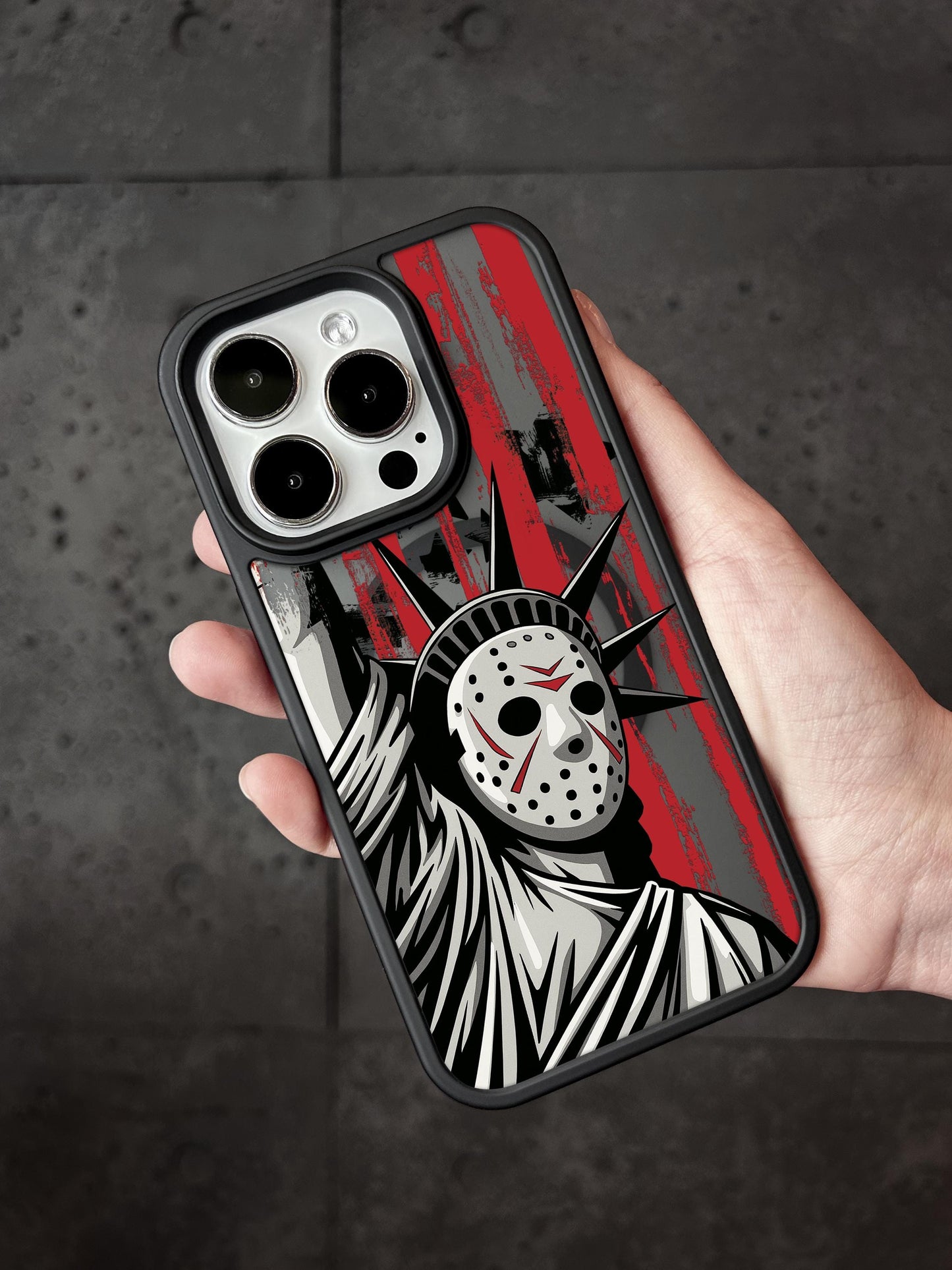 A hand holding a phone case featuring a graphic design of the Statue of Liberty with a mask on it.