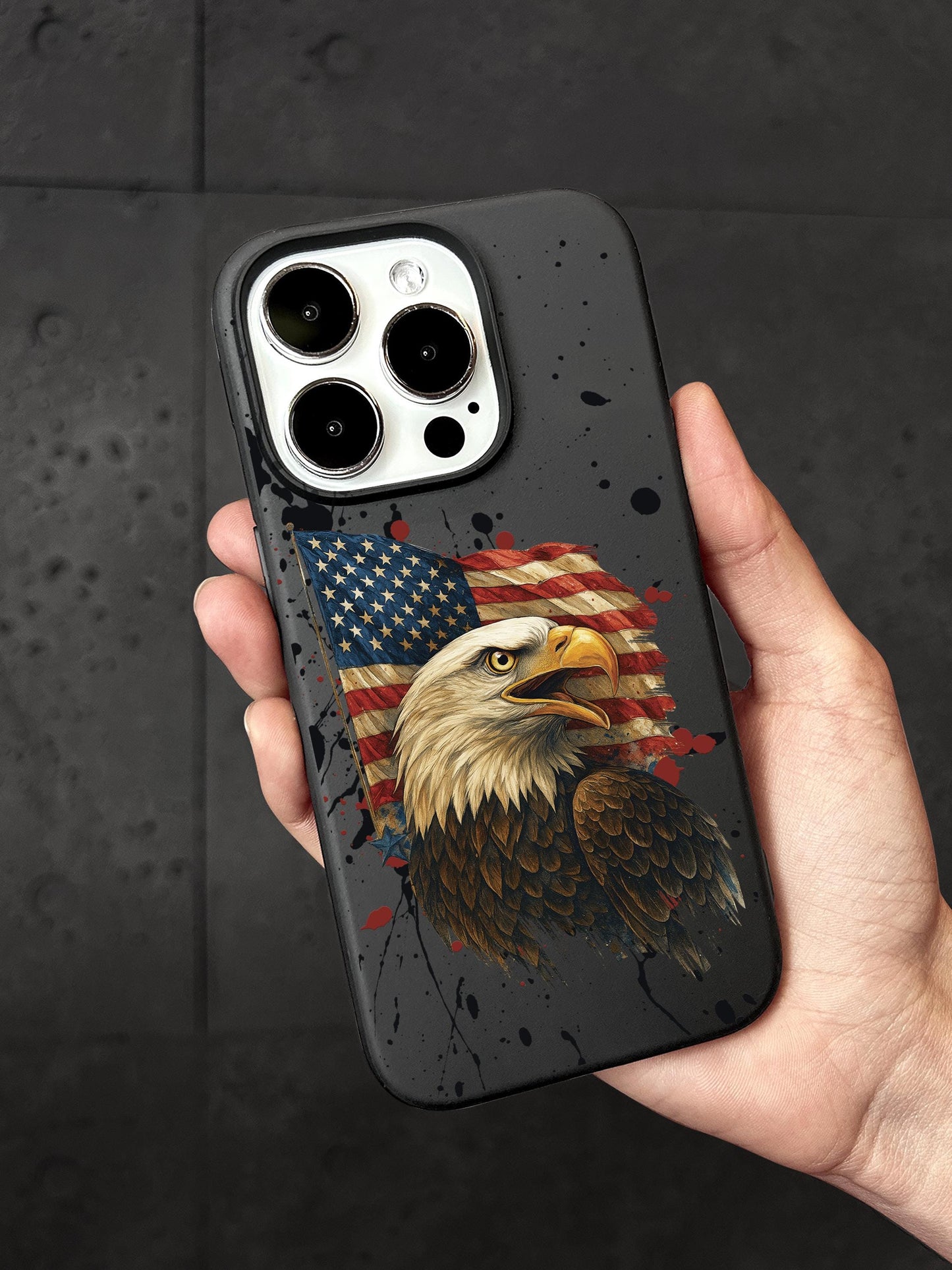 A person&#39;s hand holding a phone case with an image of an eagle and an American flag printed on it.