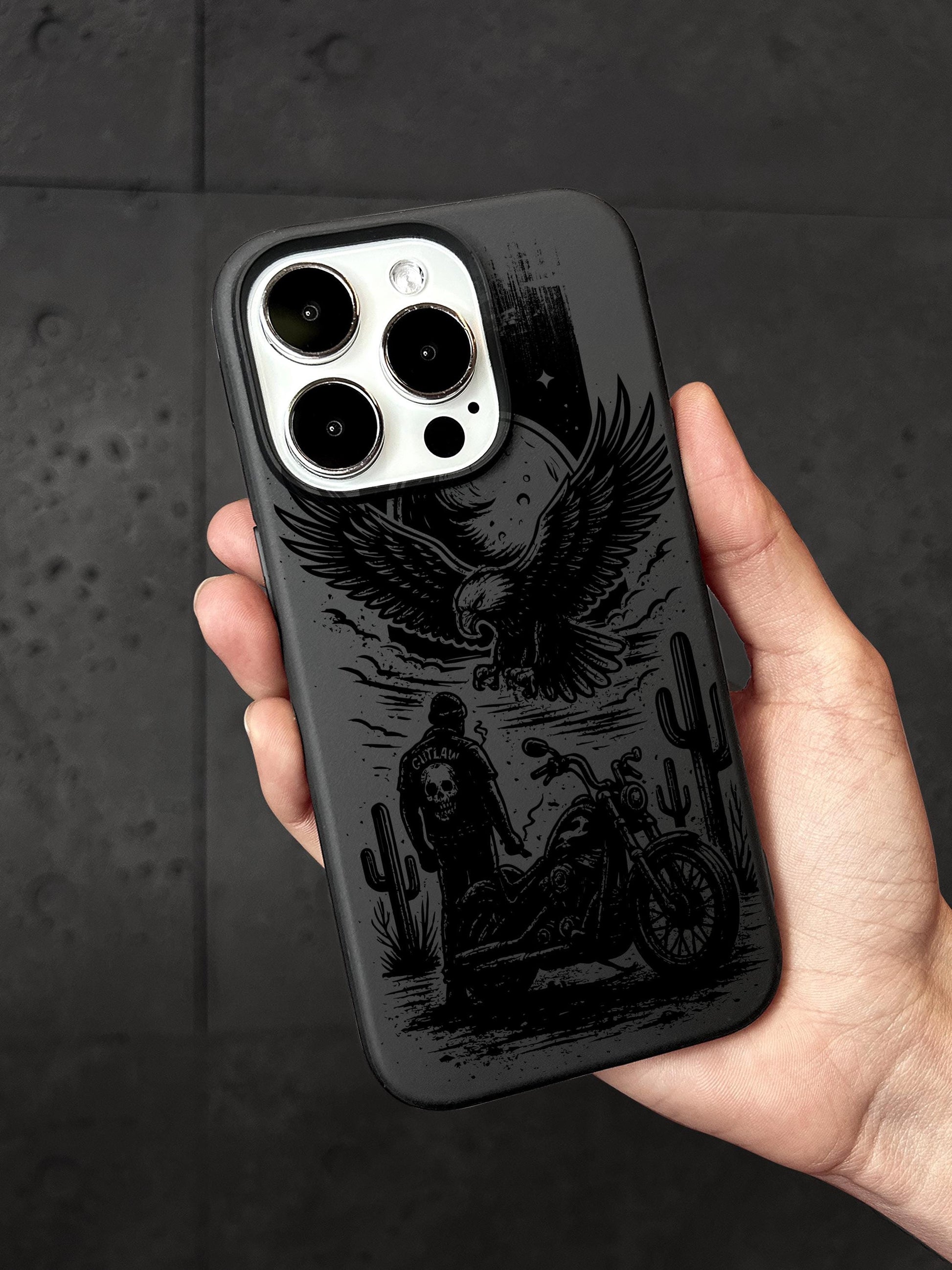 a hand holding a black phone case with a picture of a man on a motorcycle