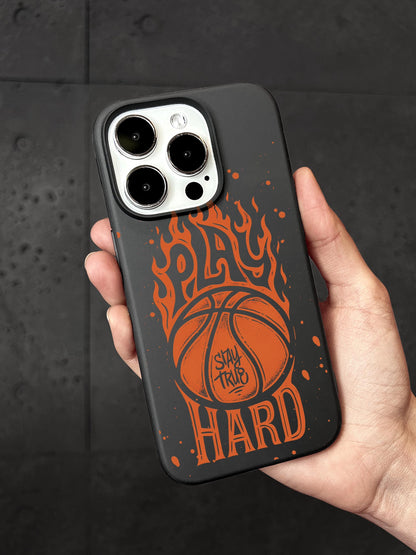 A person&#39;s hand holding a black phone case with an orange basketball design and the text &quot;PLAY HARD&quot; printed on it.