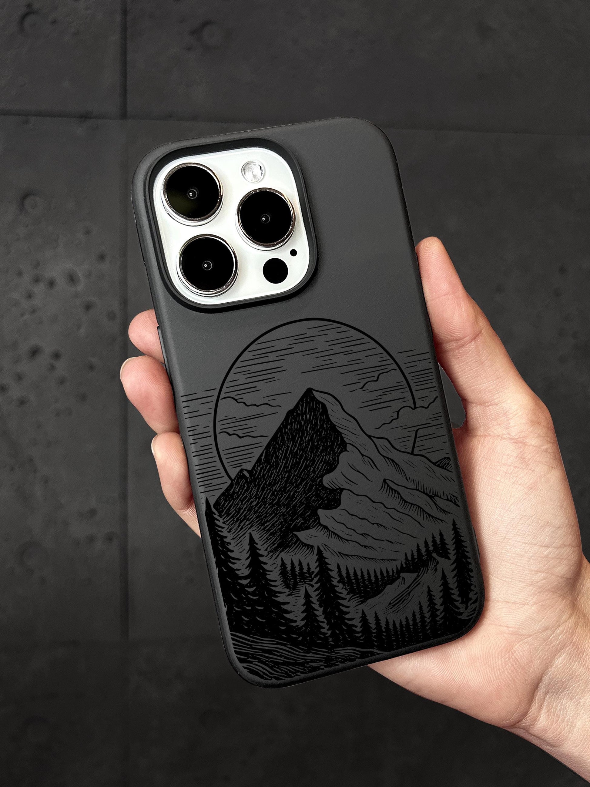 a person holding a phone case with a mountain scene on it