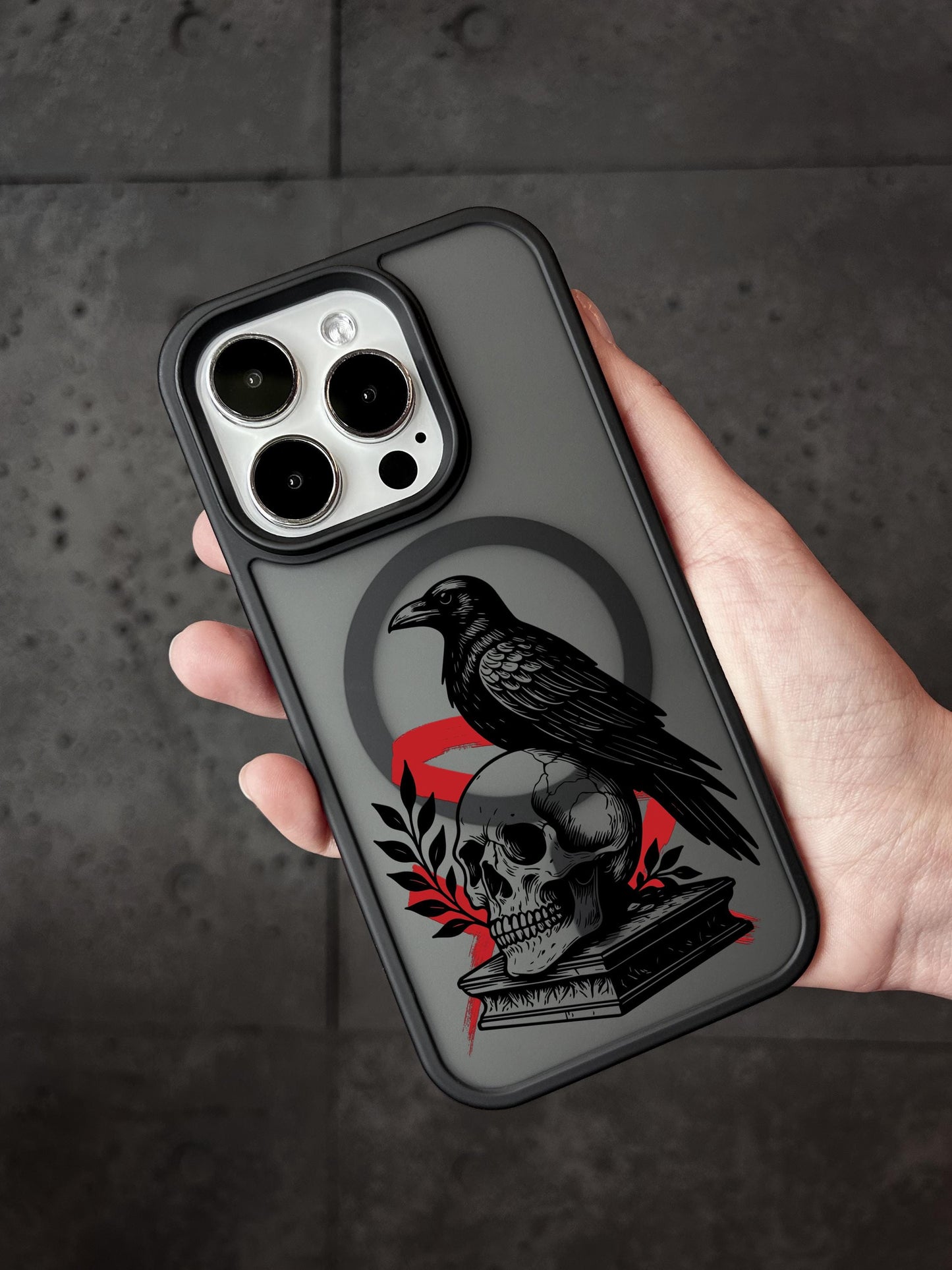 a person holding a phone case with a black bird on it