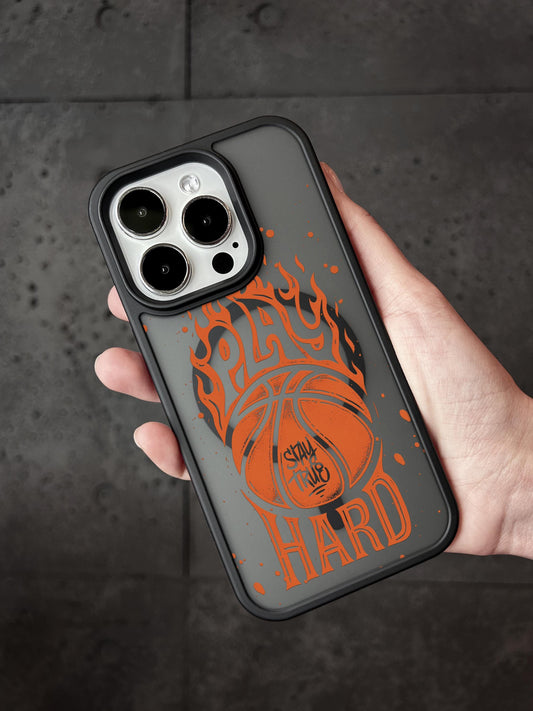 A person&#39;s hand holding a phone case with a basketball design and the text &quot;STAY HARD&quot; printed on it.
