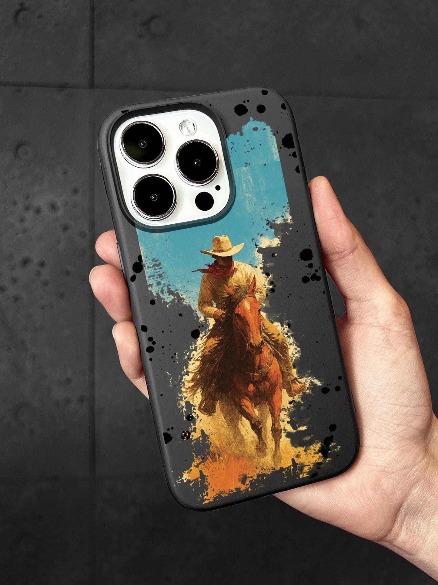 A person is holding a phone case featuring an image of a cowboy riding a horse.