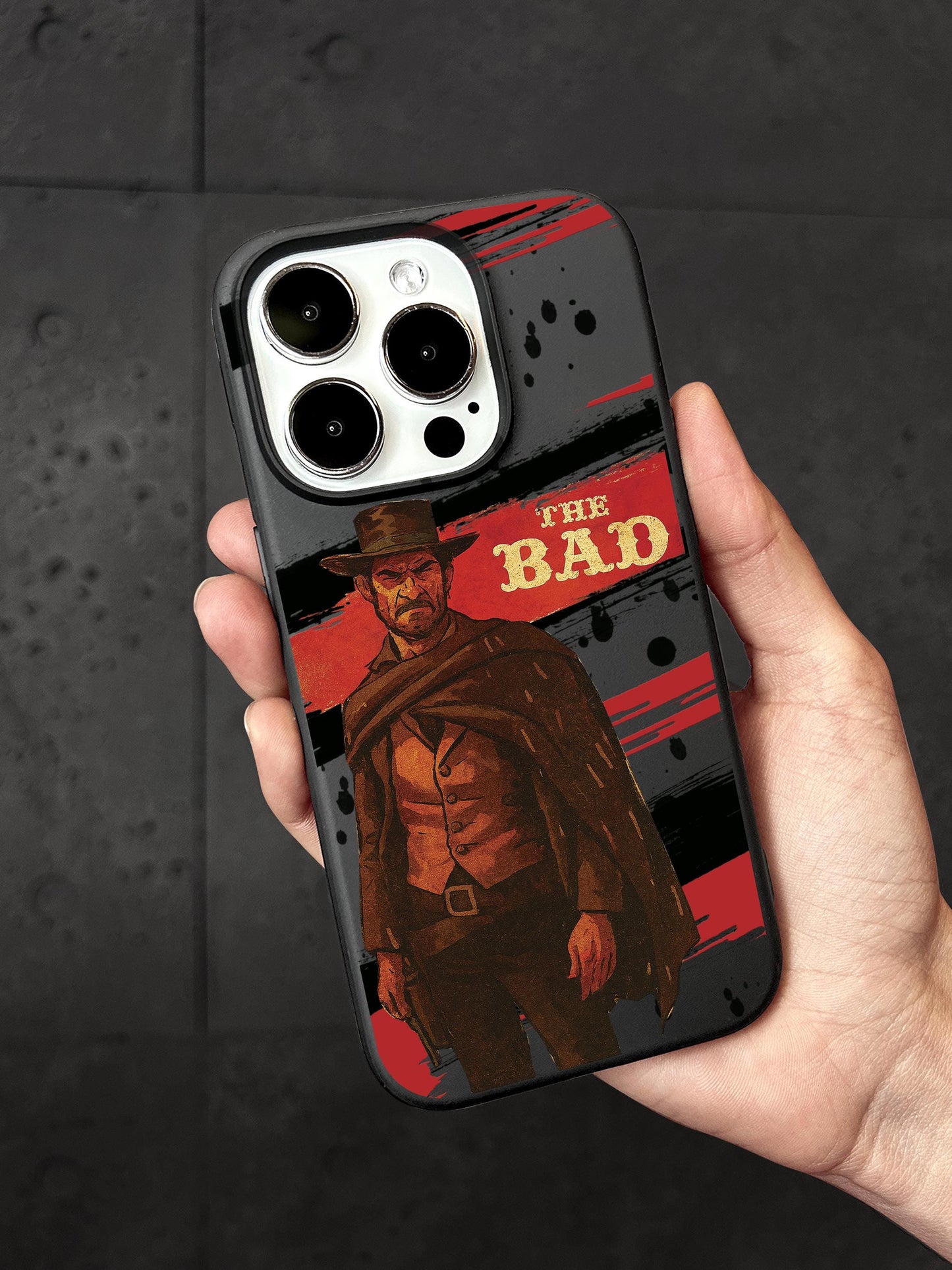 A person&#39;s hand holding a phone case featuring an illustration of a character from the movie &quot;The Good, the Bad and the Mad&quot;.