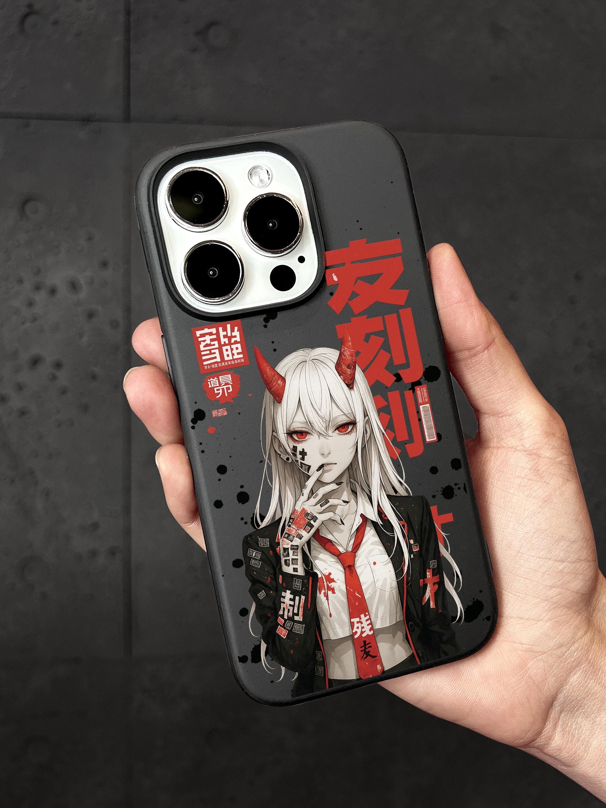 a person holding a phone case with an anime-style illustration of a character with horns and a red tie.