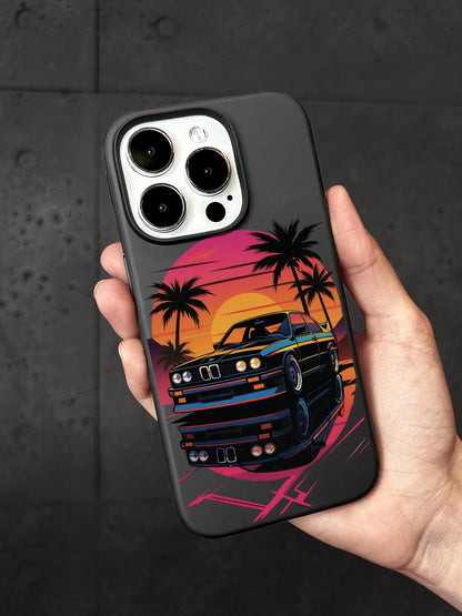 A person&#39;s hand holding a phone case with a colorful graphic of a car and palm trees on it.