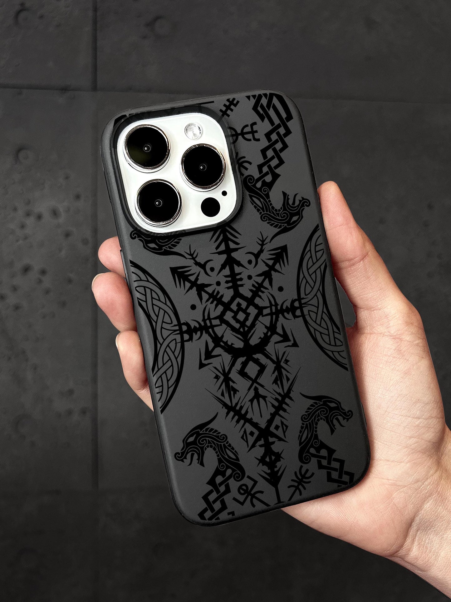 a hand holding a black and white iphone case