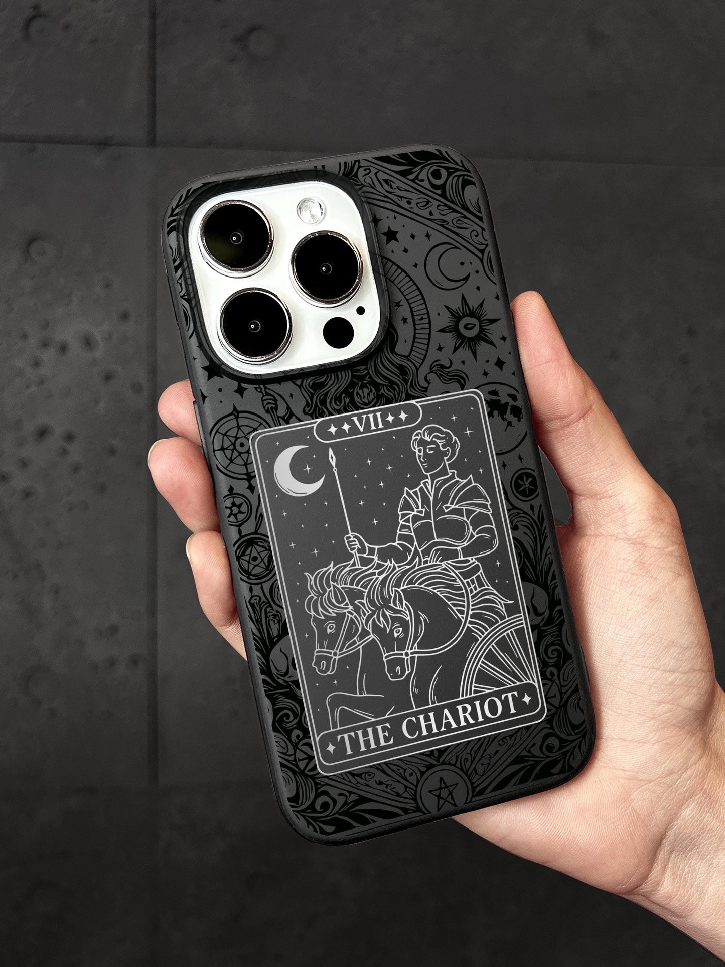 A person&#39;s hand holding a phone case with a design featuring a tarot card and a horse.