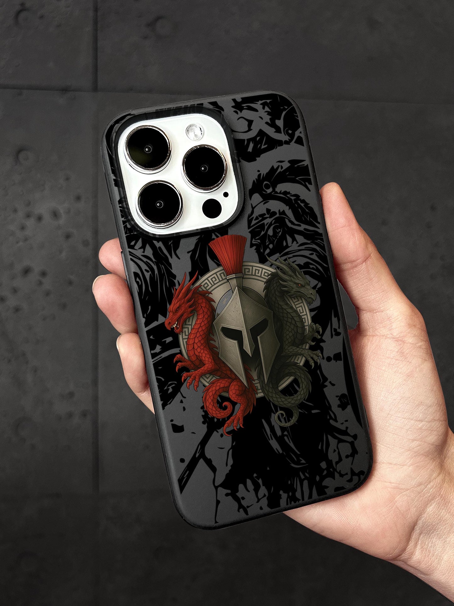 a hand holding a black phone case with a red dragon on it