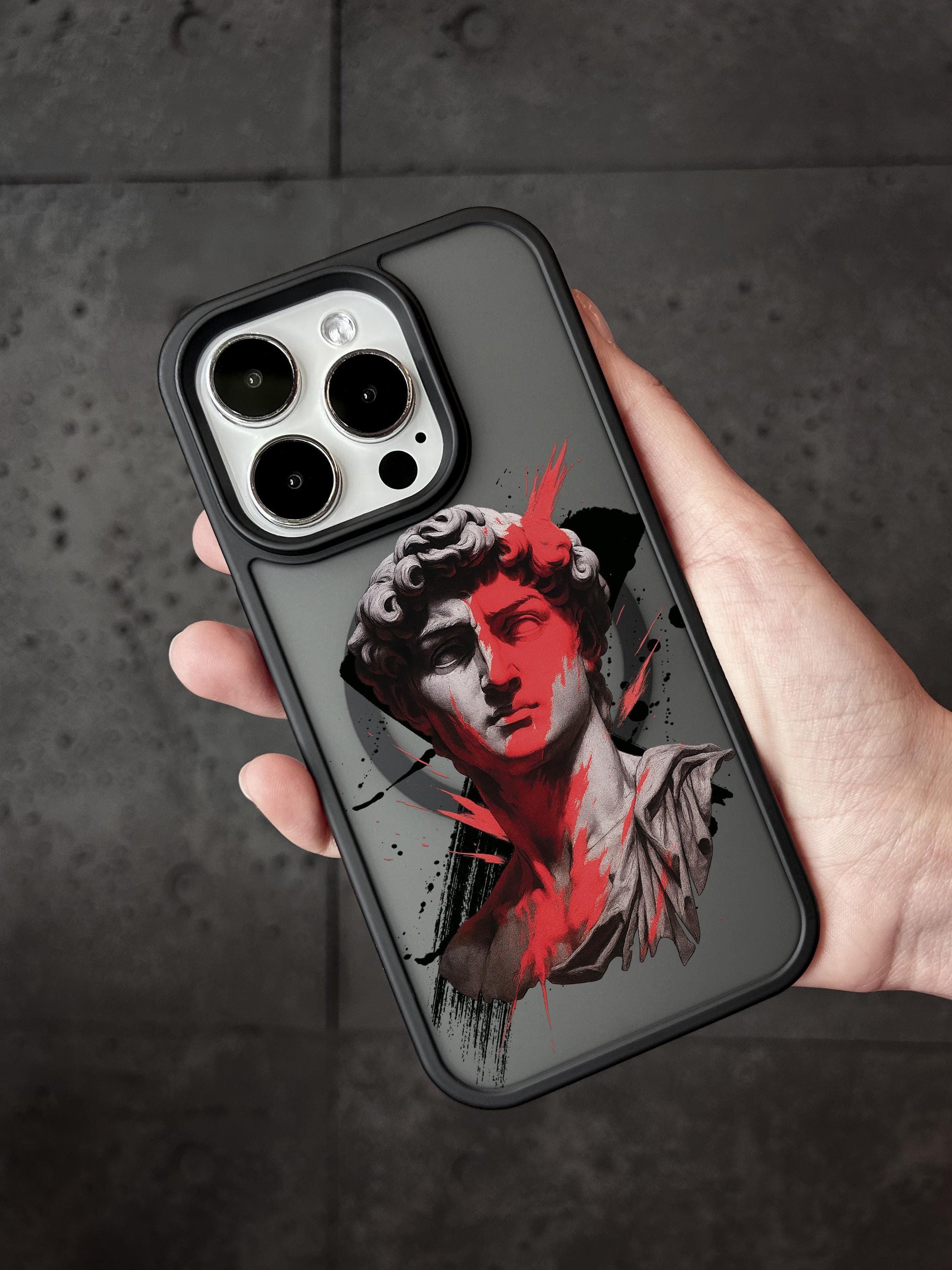 A hand holding a phone case with a stylized image of a person&#39;s face on it.