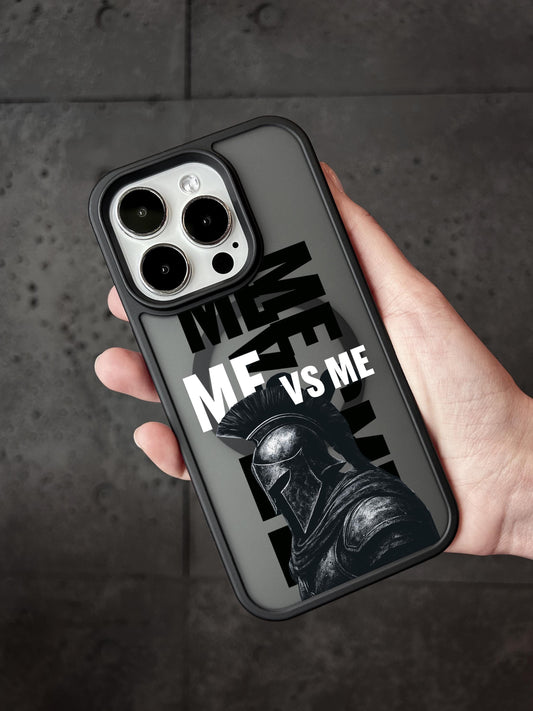 A person&#39;s hand holding a phone case with a graphic design featuring a helmeted figure and the text &quot;ME VS ME&quot; printed on it.